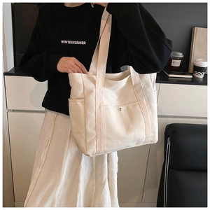 Detail view of the large capacity canvas tote bag with front snap pocket and side pouches