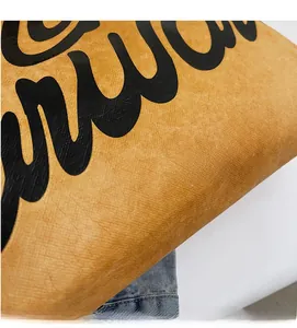Détail de la texture grainée du cabas jaune gingembre et des lettres artistiques noires