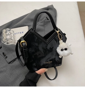 Détail du sac cabas noir motif marbre avec boucles dorées et pendentif en peluche doux