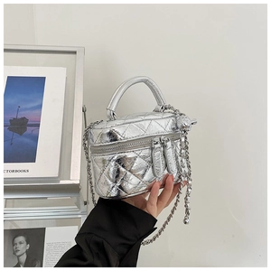 Détail du mini sac seau matelassé argenté avec bandoulière chaîne et fini métallisé