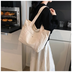 Lifestyle shot of large off-white canvas tote bag with side pocket and shoulder straps