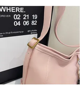 Close-up of pink shoulder bag showing strap adjustment detail and golden buckle