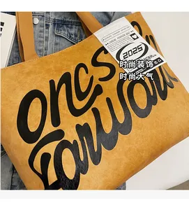 Gros plan du sac cabas jaune moutarde avec texte artistique noir et texture grainée premium