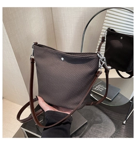 Détail du sac seau marron foncé texturé avec bouton pression argenté et bandoulière