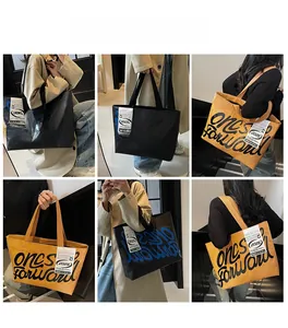 Détail du grand sac cabas en toile montrant des graffitis et des étiquettes tissées
