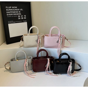 Five assorted colors of elegant mini tote bags with detachable straps and knot charms