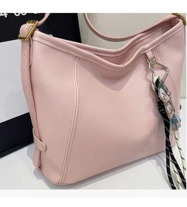 Close-up of pink PU leather Hobo bag with debossed COIIH V2DN logo and gold metal hardware