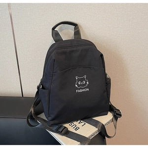 Detail of waterproof black nylon backpack featuring a cute cat graphic and side pockets