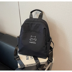 Detail of waterproof nylon backpack featuring a cartoon cat print and front pocket