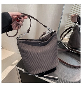 Détail du sac seau marron foncé avec texture à carreaux et bouton-pression argenté