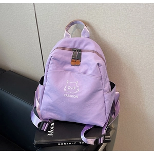 Detail view of small lavender nylon backpack with cute cartoon cat print and side pocket