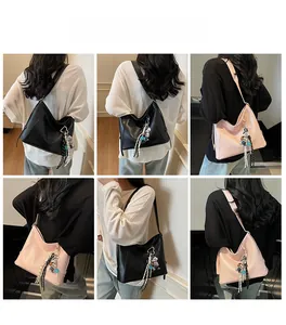 Detailed view of black and pink PU leather hobo bags with cute bear charm on models