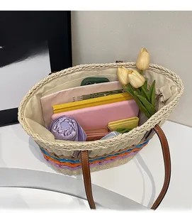 Top view of large straw tote bag showing spacious interior with leather handles and colorful stripes