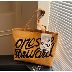 Vue détaillée du sac cabas jaune moutarde montrant la texture plissée unique du tissu