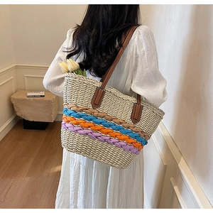 Detail of handwoven straw tote with colorful stripes and premium brown leather handles