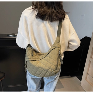 Detailed back view of an army green quilted crescent bag with wide fabric strap