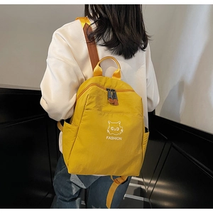 Rear view of a person wearing a vibrant yellow waterproof nylon backpack with cat print