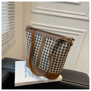 Détails du sac seau à motif pied-de-poule avec bordure en cuir marron et coutures