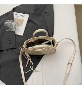 Interior view showing the large storage space and dividers of the cream handbag