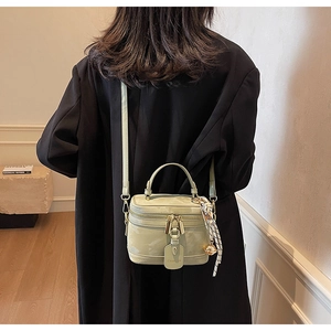 Détail d'un sac boîte en cuir verni vert menthe avec foulard en soie et finitions dorées