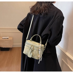 Détail du sac bandoulière vert sauge marbré avec foulard en soie et sangle en cuir