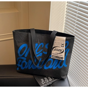 Gros plan sur un cabas noir avec imprimé graffiti bleu et étiquette tendance