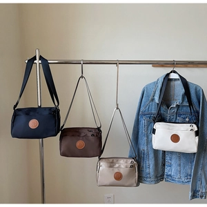 Détails de sacs à bandoulière en nylon multicouches en bleu, marron, kaki et blanc