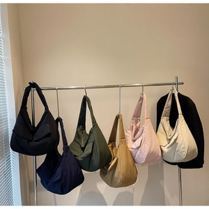 Detail showing various colors of nylon tote bags hanging in a neat minimalist display