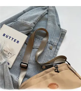 Détail du sac bandoulière en nylon kaki avec large sangle réglable et double zip