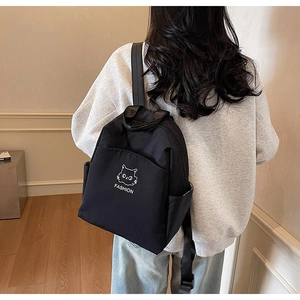 Detail view of the black waterproof nylon backpack on a model showing size and comfort