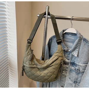 Detail of olive green quilted nylon half-moon bag with adjustable wide strap and zipper