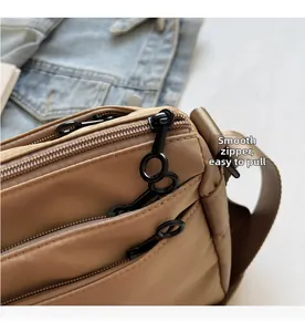 Détail des fermetures éclair noires et compartiments sur le sac à bandoulière en nylon