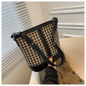 Détail du sac seau à motif pied-de-poule avec bordure en cuir noir et clous dorés