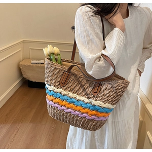 Detail showing multi-colored striped straw tote bag with brown faux leather shoulder straps