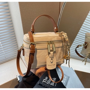 Détail d'un sac boîte vintage crème avec poignée en cuir marron et zip doré double