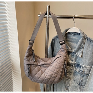 Detail of quilted diamond stitching and woven rope zipper on mauve crescent bag
