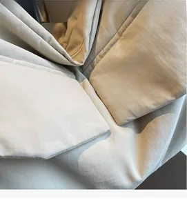 Macro shot of cream ripstop fabric showing detailed stitching and fine grid texture