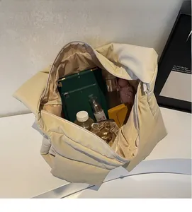 Interior view of off-white quilted tote bag showing large capacity and zipper closure