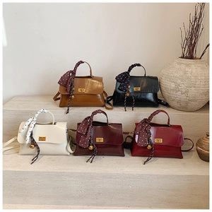 Detailed arrangement of stylish faux leather crossbody bags with silk scarves and metal locks