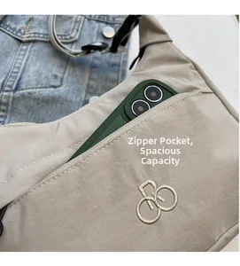 Dettaglio della borsa beige in nylon con tasca frontale a zip e logo ricamato