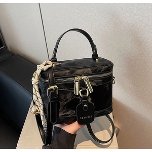 Détail d'un sac à main boîte noir vintage avec fini marbré et fermetures éclair dorées