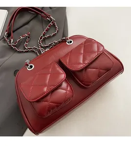 Detail of burgundy quilted faux leather bag with silver chain strap and front pockets