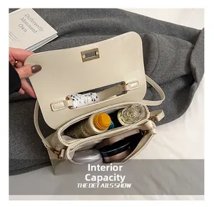 Internal capacity of minimalist beige shoulder bag with daily items and metal lock