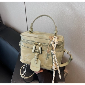 Détail du sac boîte vintage vert clair avec fermeture dorée et bandoulière en cuir élégante
