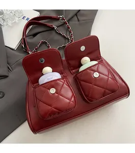 Detail of burgundy quilted bag with dual front pockets and silver chain strap