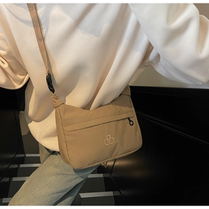 Dettaglio della borsa a tracolla in nylon kaki con tasca frontale e cinturino a fibbia