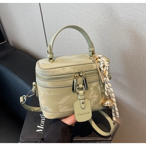 Détail du sac boîte vert clair avec texture marbre, double zip et étiquette de marque