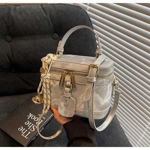 Détail du sac boîte à motif marbre gris avec zips dorés et bandoulière amovible