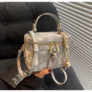 Détail du mini sac boîte marbré argenté avec ferrures dorées et breloque cloche