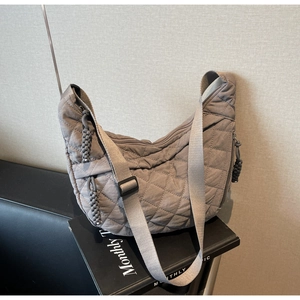 Detailed view of grey quilted nylon hobo bag featuring decorative woven knots and wide strap